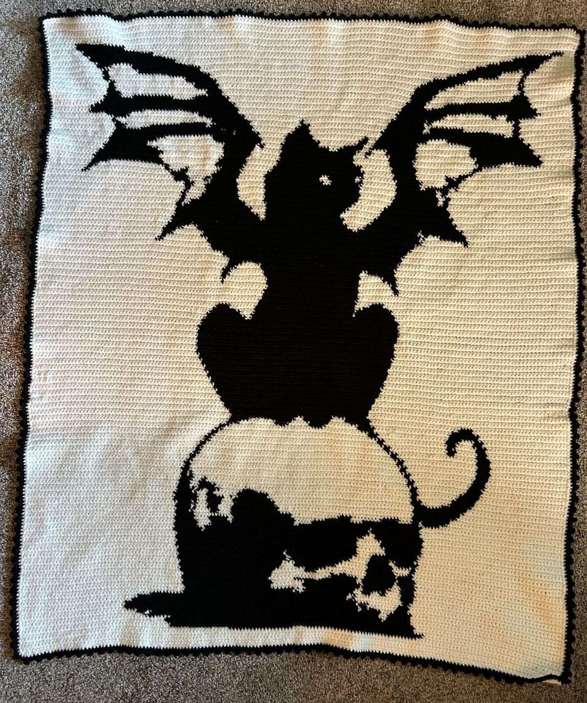 Finished black and white winged cat crochet blanket made from a gothic Halloween graphghan pattern